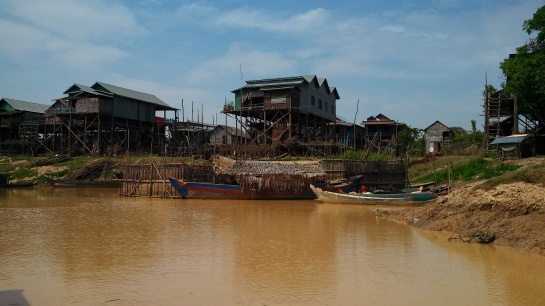 They build the houses up several stories because the entire town floods during the rainy season and they have to take boats/jetpacks to school